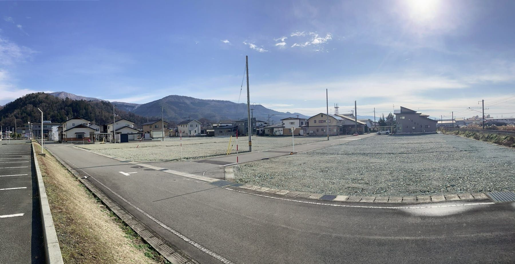 Sun+新高田の全景。前面道路と造成済みの区画、奥に山並み