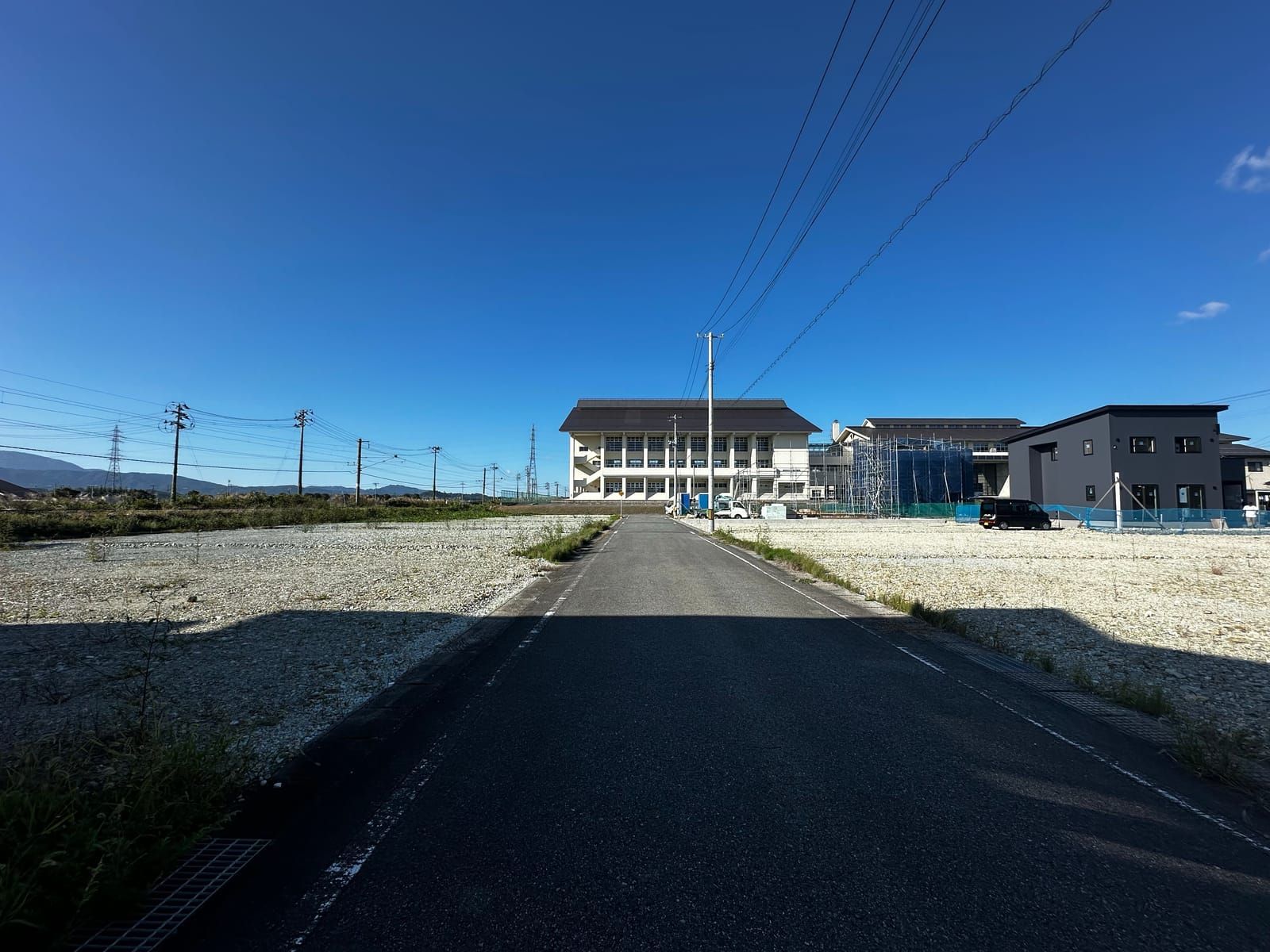 分譲地の中を通る前面道路。両側に区画が並び、正面に村山市立楯岡中学校
